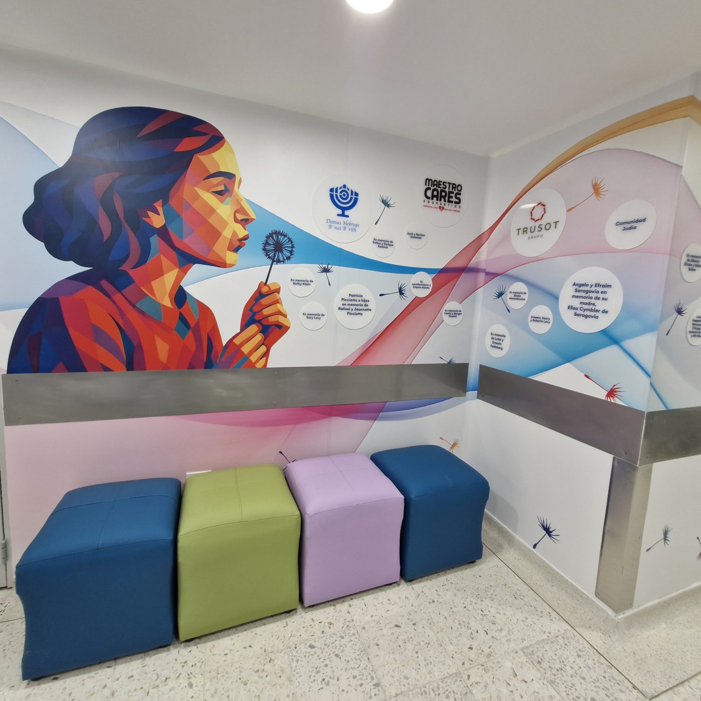 Sala de espera con mural de colores y asientos para las familias.
